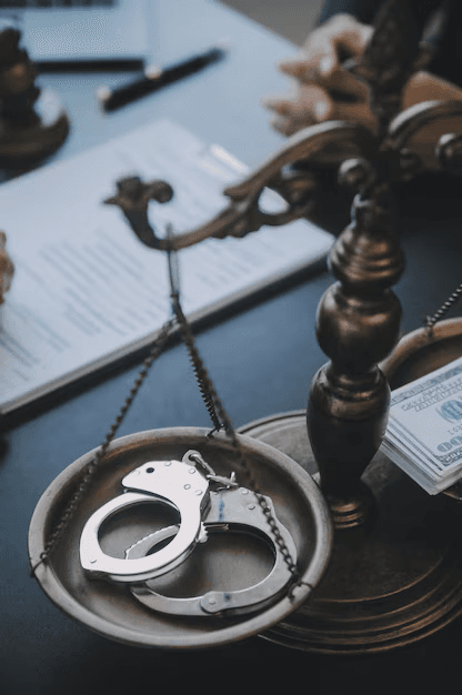 Balanza de la justicia con esposas en un platillo y dinero en el otro